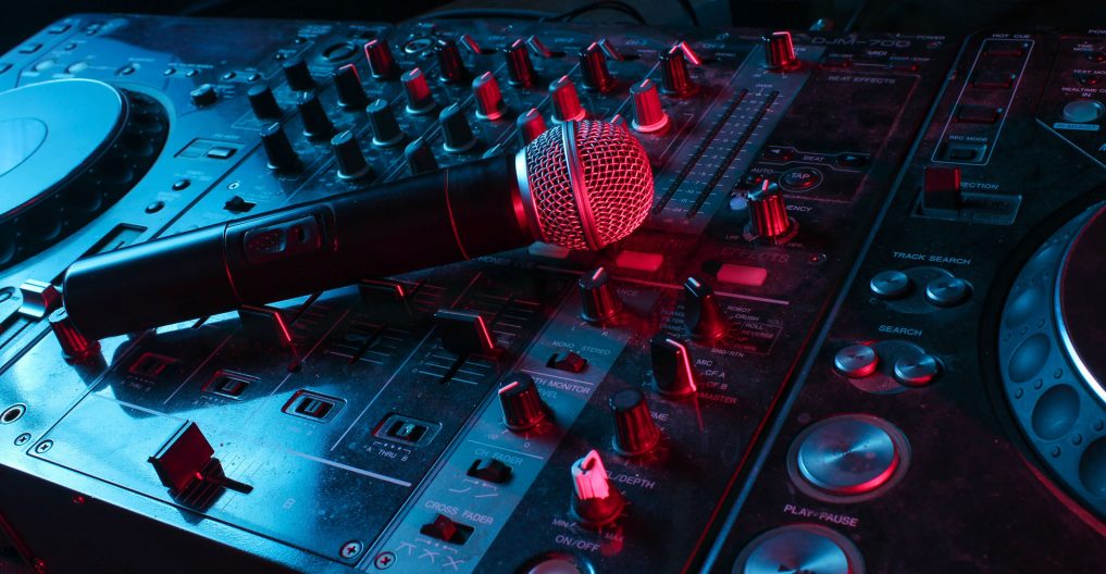 Night club, nightlife concept. Disco. Microphone on DJ remote. Neon red blue light Night club, nightlife concept. Disco. Microphone on DJ remote. Neon red blue light